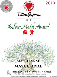Bottle of SANI-LLC Masclianae Extra Virgin Olive Oil with a dark glass container and label, displayed on a wooden surface.